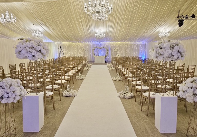 Ceremony room decorated with fairy lights, chandeliers and flowers 